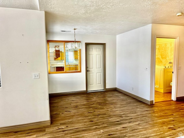 1050 W Red Hills Pkwy Unit 64, Washington, UT 84780 - unfurnished dining area with wood finished floors, a textured ceiling, and baseboards
