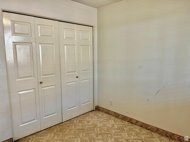 1050 W Red Hills Pkwy Unit 64, Washington, UT 84780 - unfurnished bedroom with baseboards, a closet, and light colored carpet