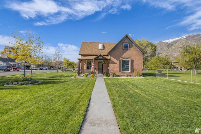 311 E 100 S, Springville, UT 84663 - view of front facade with brick siding, a front lawn, fence, and a mountain view