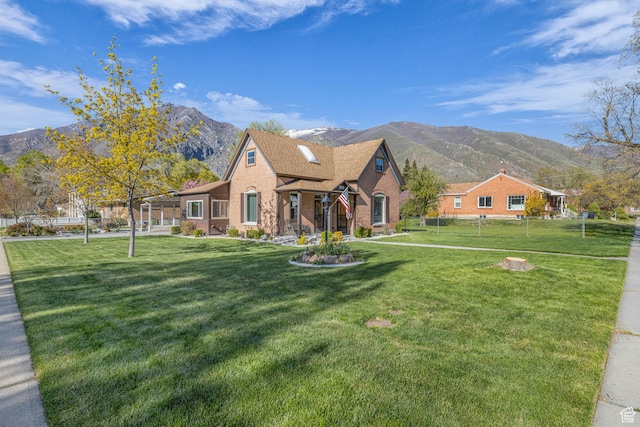 311 E 100 S, Springville, UT 84663 - view of front of property with a front lawn, a mountain view, fence, brick siding, and roof with shingles