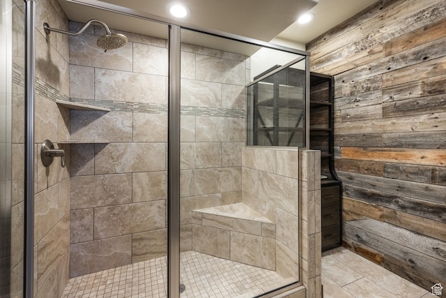 bathroom featuring recessed lighting, wooden walls, and a stall shower