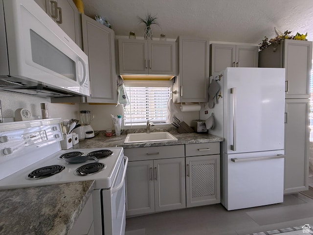 1150 W Red Hills Pkwy Unit 137, Washington, UT 84780 - kitchen featuring white appliances, a sink, gray cabinets, a textured ceiling, and light stone countertops