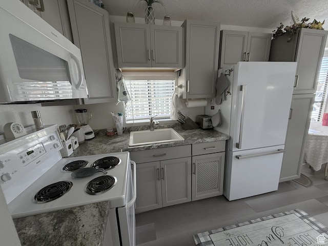 1150 W Red Hills Pkwy Unit 137, Washington, UT 84780 - kitchen with white appliances, gray cabinets, a sink, light countertops, and a textured ceiling