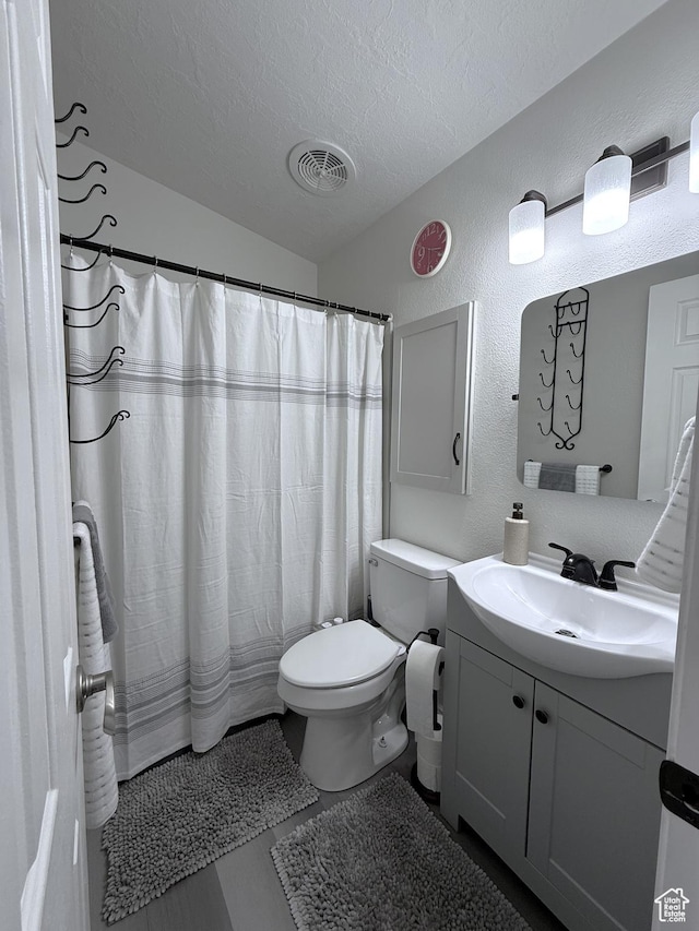 1150 W Red Hills Pkwy Unit 137, Washington, UT 84780 - full bathroom featuring a textured ceiling, a textured wall, vanity, toilet, and a shower with shower curtain