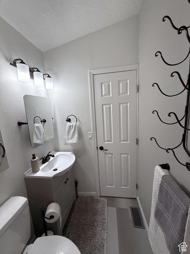 1150 W Red Hills Pkwy Unit 137, Washington, UT 84780 - half bath with toilet, vanity, a textured ceiling, and baseboards