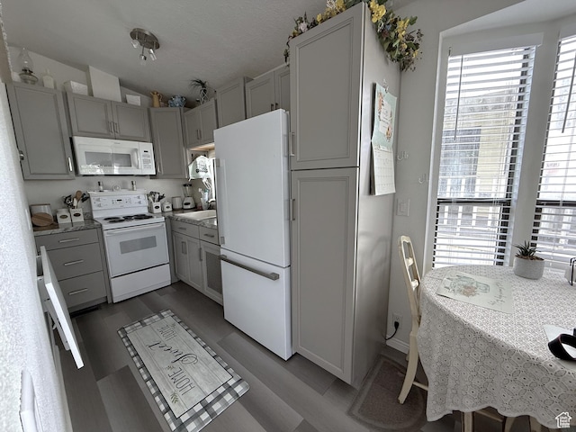 1150 W Red Hills Pkwy Unit 137, Washington, UT 84780 - kitchen featuring white appliances, vaulted ceiling, light wood finished floors, and gray cabinetry