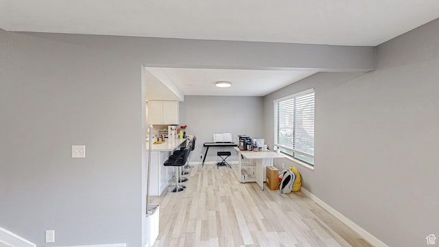 office space with light wood-style flooring and baseboards