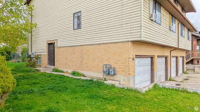 view of property exterior featuring an attached garage, brick siding, a yard, and cooling unit