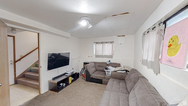 carpeted living area featuring stairs