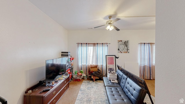 living area with ceiling fan and carpet flooring
