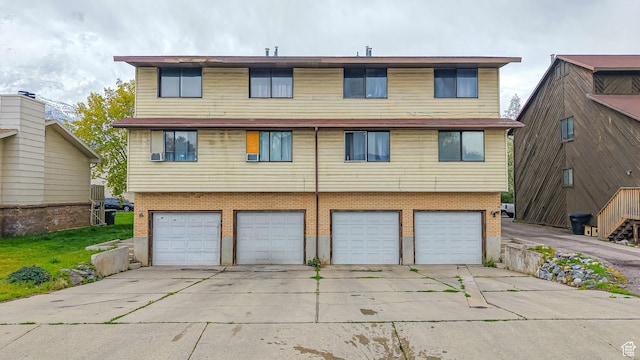 exterior space featuring a garage, brick siding, and concrete driveway