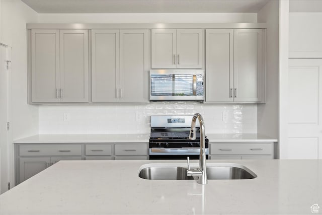 3448 S 3100 W Unit 153, West Haven, UT 84401 - kitchen with appliances with stainless steel finishes, gray cabinetry, light stone countertops, and tasteful backsplash