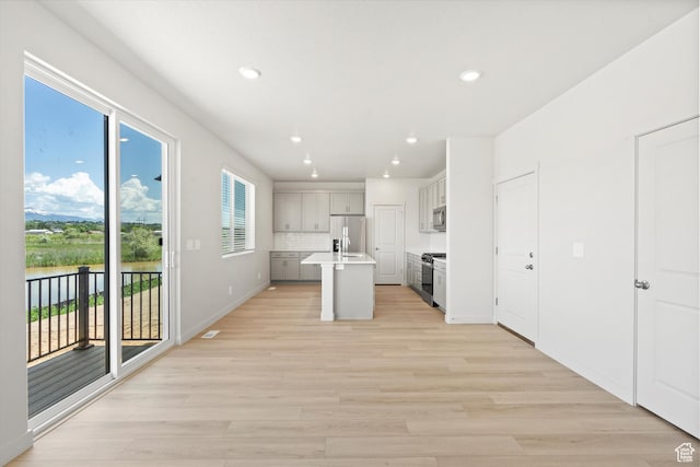 3448 S 3100 W Unit 153, West Haven, UT 84401 - kitchen with appliances with stainless steel finishes, light wood-style floors, an island with sink, recessed lighting, and light countertops