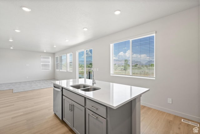 3448 S 3100 W Unit 153, West Haven, UT 84401 - kitchen featuring gray cabinets, stainless steel dishwasher, light wood-type flooring, light countertops, and an island with sink