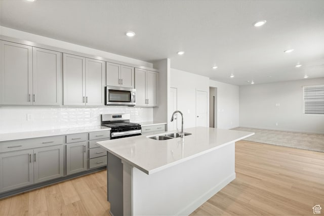 3448 S 3100 W Unit 153, West Haven, UT 84401 - kitchen with appliances with stainless steel finishes, gray cabinetry, backsplash, light wood-type flooring, and light countertops