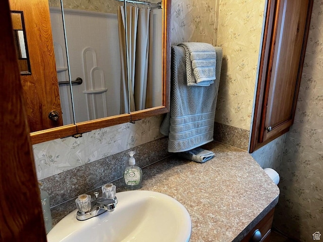 1150 W Red Hills Pkwy Unit 21, Washington, UT 84780 - bathroom featuring wallpapered walls, a shower with curtain, and vanity