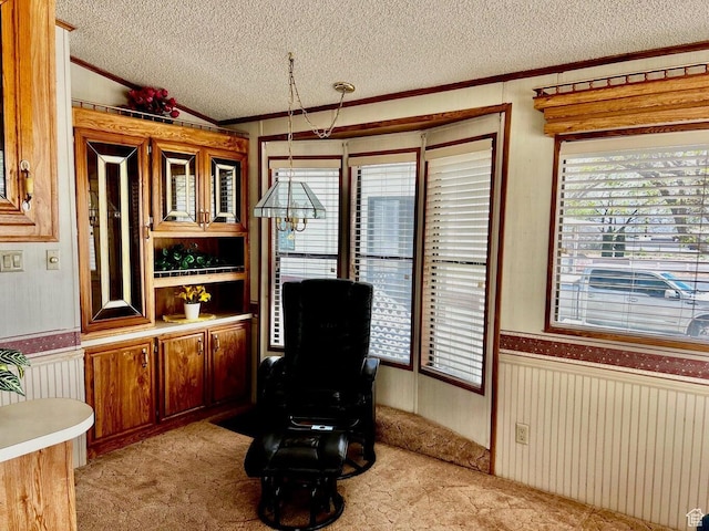 1150 W Red Hills Pkwy Unit 21, Washington, UT 84780 - sitting room with wood walls, crown molding, wainscoting, a textured ceiling, and light colored carpet