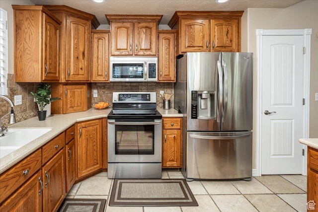 5195 S 5825 W, Hooper, UT 84315 - kitchen with brown cabinets, backsplash, light countertops, and stainless steel appliances
