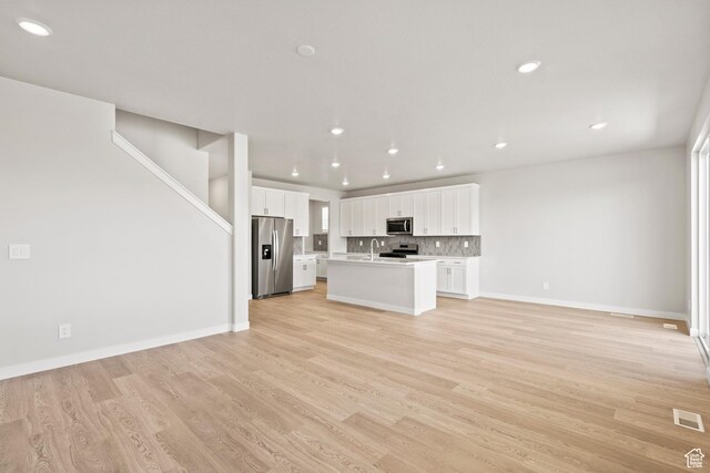 3444 S 3100 W Unit 154, West Haven, UT 84401 - unfurnished living room with light wood finished floors, recessed lighting, baseboards, and stairs