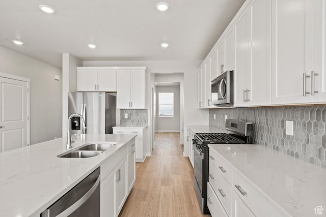 3444 S 3100 W Unit 154, West Haven, UT 84401 - kitchen featuring stainless steel appliances, a sink, light wood-style flooring, white cabinets, and light stone counters