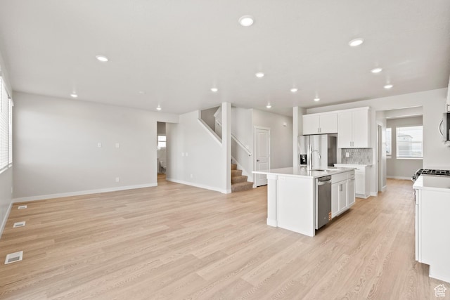 3444 S 3100 W Unit 154, West Haven, UT 84401 - kitchen with light wood-style flooring, appliances with stainless steel finishes, a center island with sink, white cabinetry, and light countertops