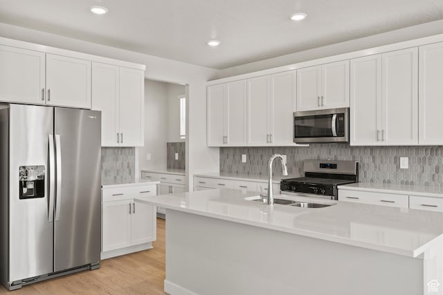 3444 S 3100 W Unit 154, West Haven, UT 84401 - kitchen with appliances with stainless steel finishes, a sink, an island with sink, light wood finished floors, and light countertops