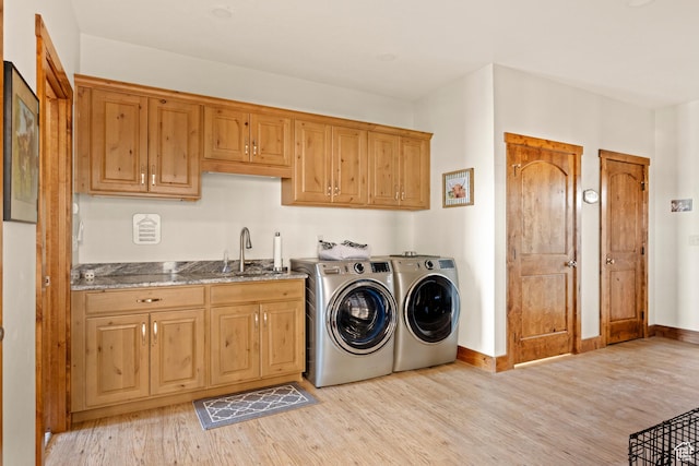 1428 N Broad Hollow Rd, Garden City, UT 84028 - laundry room with washer and clothes dryer, cabinet space, a sink, and light wood-style floors