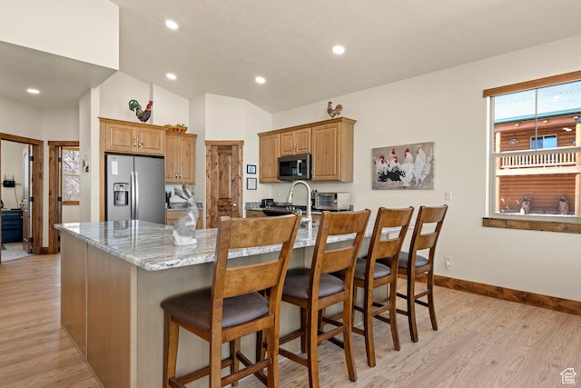 1428 N Broad Hollow Rd, Garden City, UT 84028 - kitchen with recessed lighting, lofted ceiling, light wood finished floors, light stone counters, and stainless steel appliances