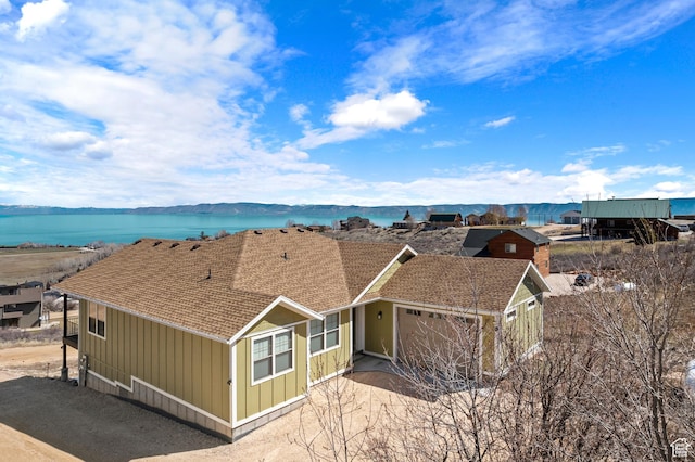 1428 N Broad Hollow Rd, Garden City, UT 84028 - view of front facade featuring board and batten siding, roof with shingles, a water view, and a garage