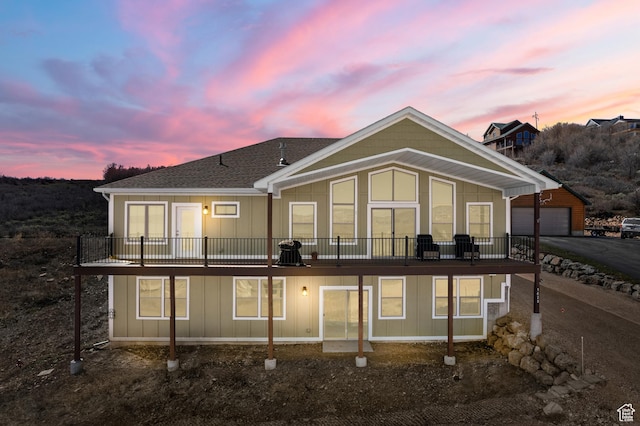 1428 N Broad Hollow Rd, Garden City, UT 84028 - back of property at dusk featuring board and batten siding, a detached garage, and roof with shingles