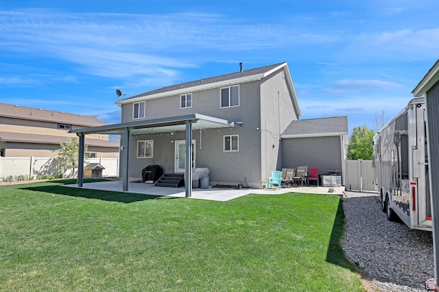 rear view of property with stucco siding, a yard, a patio area, and a fenced backyard