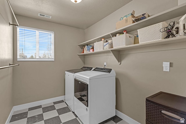 clothes washing area featuring baseboards, visible vents, independent washer and dryer, light floors, and laundry area