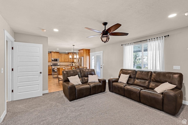 living room featuring light colored carpet, ceiling fan, baseboards, and recessed lighting