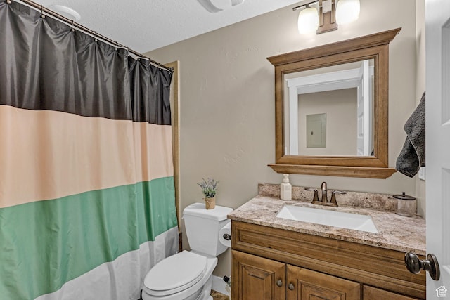 bathroom with toilet, a shower with shower curtain, vanity, and a textured ceiling