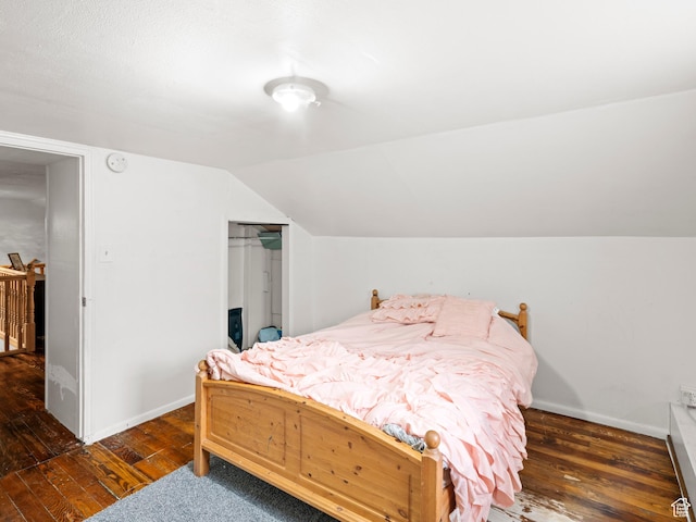 bedroom with vaulted ceiling, baseboards, a closet, and wood-type flooring