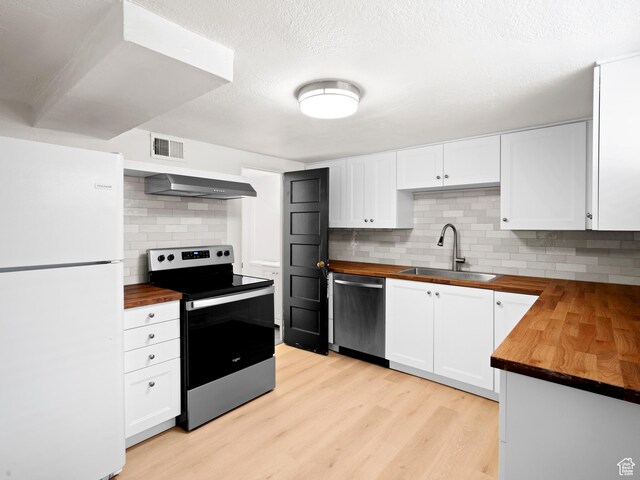 kitchen featuring wood counters, stainless steel appliances, and a sink