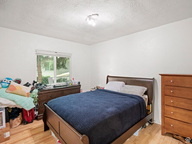 bedroom featuring a textured ceiling and light wood-type flooring