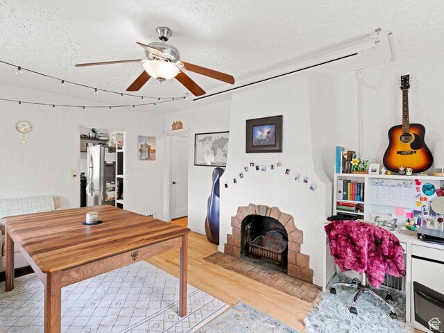 office featuring a ceiling fan, a textured ceiling, and light wood-style floors