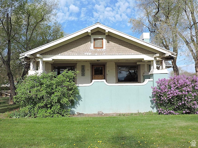 view of front facade with a front lawn and a chimney
