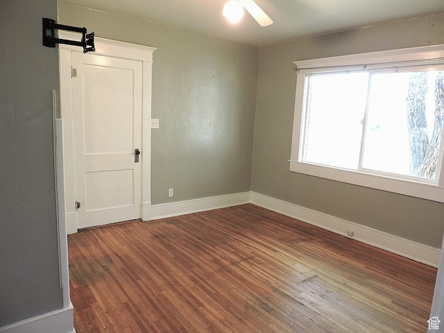 spare room with wood finished floors, baseboards, and ceiling fan