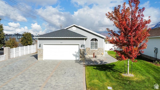 single story home featuring an attached garage, fence, and stone siding
