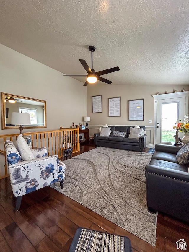 living room with ceiling fan, lofted ceiling, wood finished floors, and a textured ceiling
