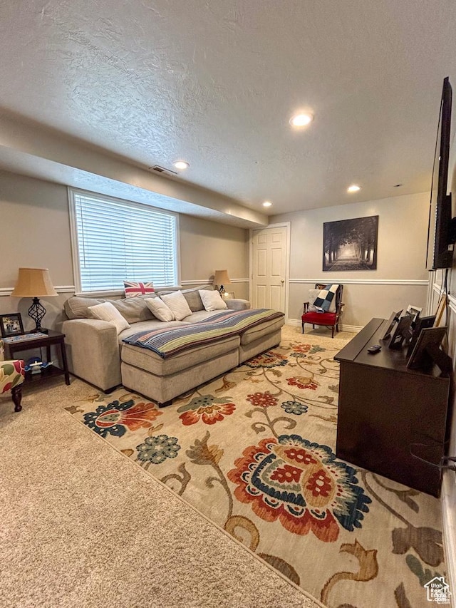 living room featuring carpet flooring, a textured ceiling, visible vents, and recessed lighting