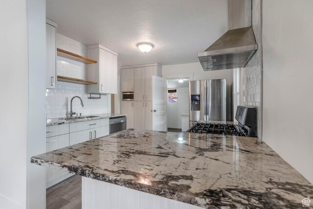 751 E Browning Ave S, Salt Lake City, UT 84105 - kitchen with open shelves, a sink, stainless steel appliances, wall chimney exhaust hood, and a peninsula