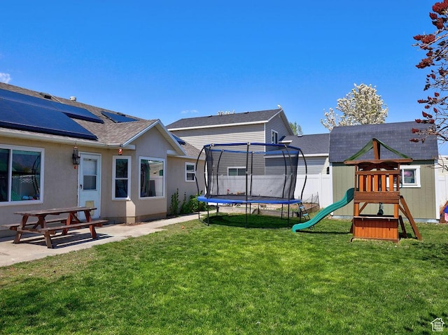 view of yard with fence, a patio, a playground, and a trampoline