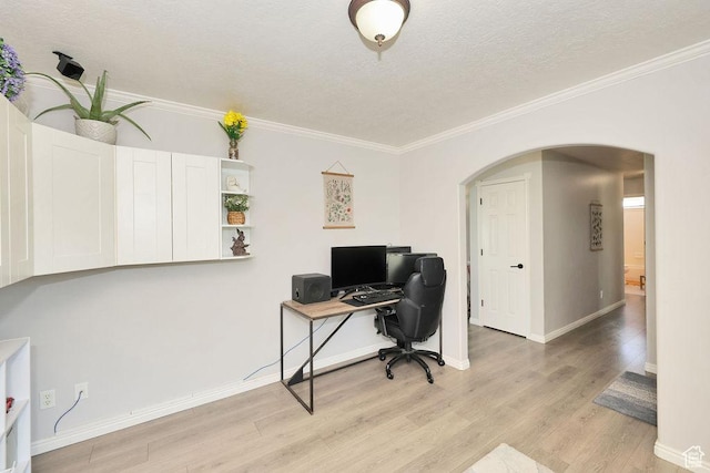 office area with crown molding, a textured ceiling, arched walkways, light wood-style flooring, and baseboards