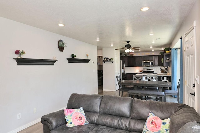 living room featuring recessed lighting, wood finished floors, a ceiling fan, and baseboards