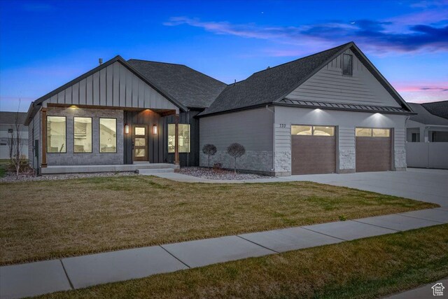 733 E 750 S, Preston, ID 83263 - view of front of house featuring concrete driveway, board and batten siding, a standing seam roof, a lawn, and a garage