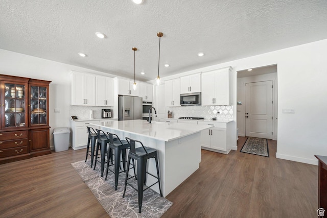 788 N 2100 E, Spanish Fork, UT 84660 - kitchen with decorative backsplash, dark wood-style floors, a breakfast bar, and stainless steel appliances