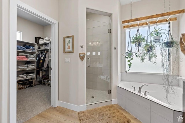 1920 W 180 N, Hurricane, UT 84737 - bathroom featuring baseboards, wood finished floors, a shower stall, a garden tub, and a walk in closet